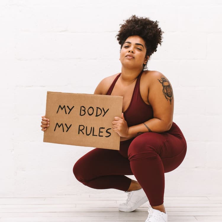 A black woman with a 'my body my choice' sign.